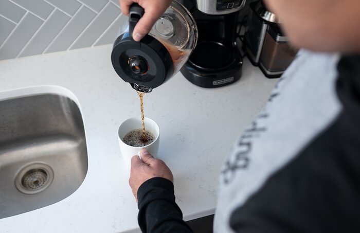 Pouring a cup of coffee.